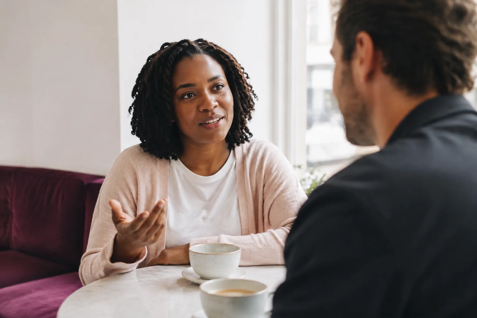 A woman and her date talking over coffee at a cafe.